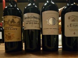 4 bouteilles de vins rouge sur ;a table. Millésime 2020